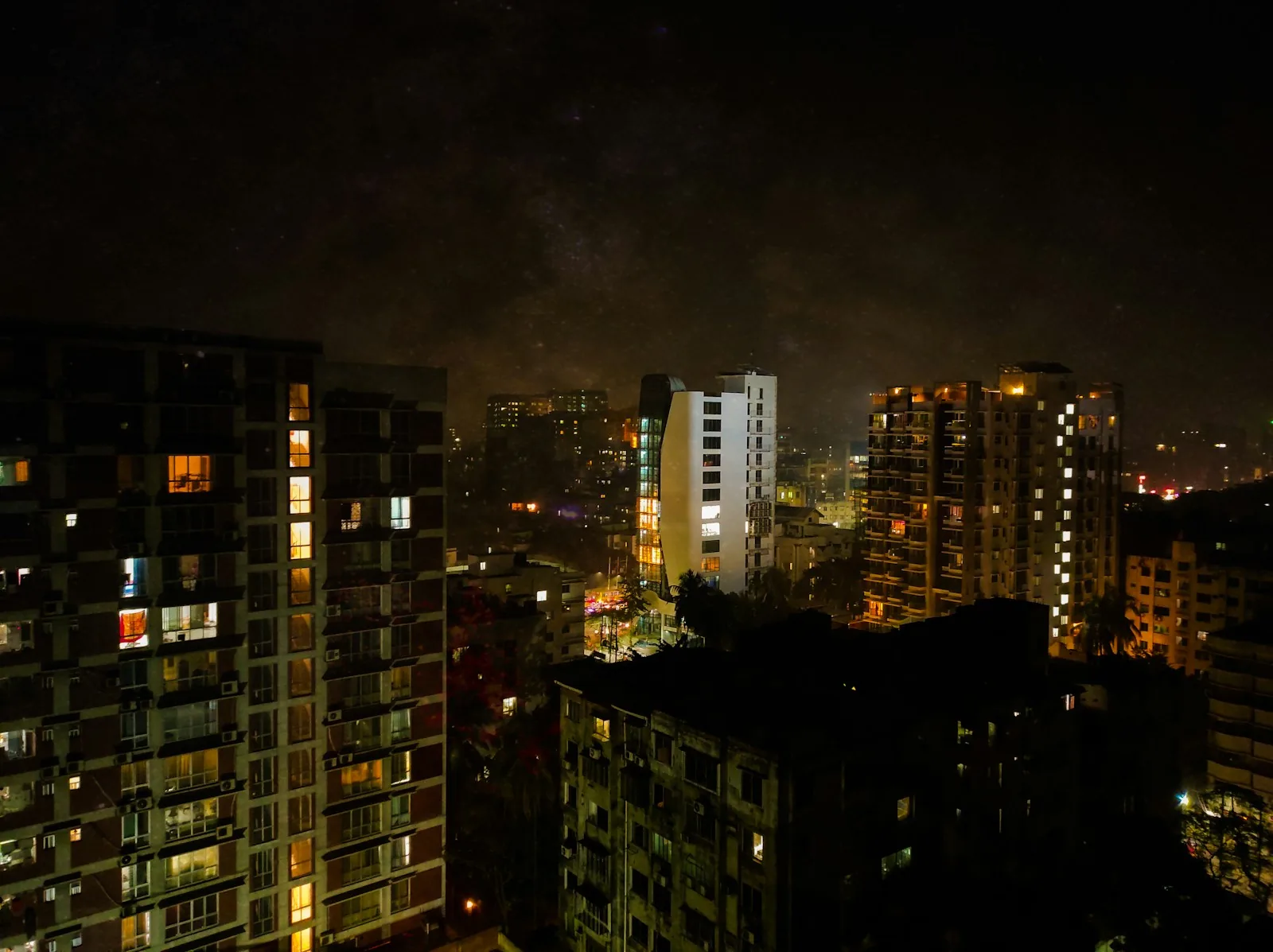 Dhaka residential towers glowing with lit windows at night